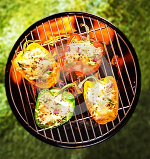 Stuffed veggy bell peppers grilling on a BBQ