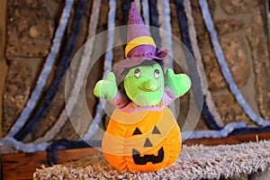 Stuffed witch inside carved pumpkin