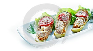 Stuffed zucchini boats filled with a sausage mixture topped with cheese. Ketogenic low-carb meal