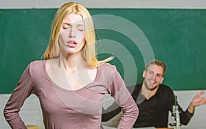 Stumbling through a lesson. Cute woman standing in classroom with teacher. University or college student. High school