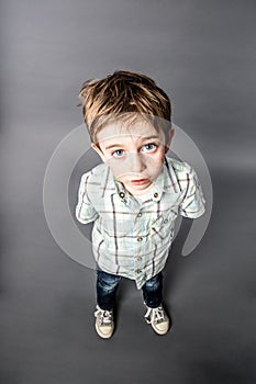 Stunned beautiful young boy staring for surprise, high angle view