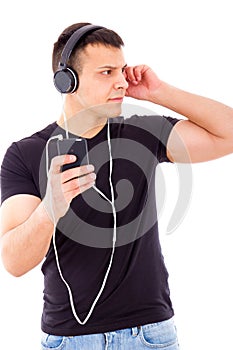 Stunned curious man listening something on mobile over headphone
