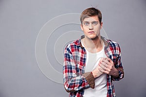 Stunned dazed man in checkered shirt with hand on chest