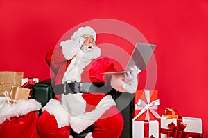 Stunned hard-working fat bearded man St Nicholas sitting on armchair shop delivery checking address list clients web
