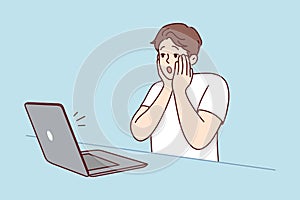 Stunned man shocked by news on computer