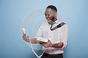 Stunned worker holding a landline phone