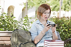 Stunned Young Female Student Outside Texting on Cell Phone