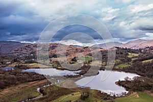 Stunning aerial drone landscape image over River Brathay near Elterwater in Lake District with Langdale Pikes in distance