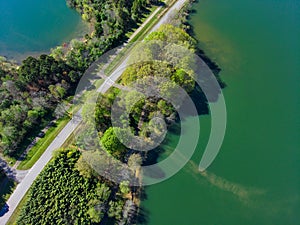 A stunning aerial shot of the lush vast green lake water and the lush green trees and plants on the banks of the lake
