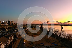 A stunning aerial shot of the Mississippi river with Memphis-Arkansas Bridge over the water with a stunning red and yellow sunset