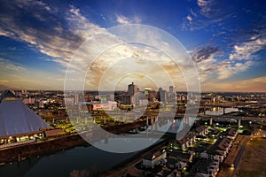 A stunning aerial shot of the skyscrapers, lights and buildings in the cityscape along the Mississippi river at sunset