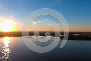 A stunning aerial shot of the vast blue waters of the Mississippi river with powerful clouds and a gorgeous sunset