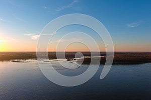 A stunning aerial shot of the vast blue waters of the Mississippi river with powerful clouds and a gorgeous sunset