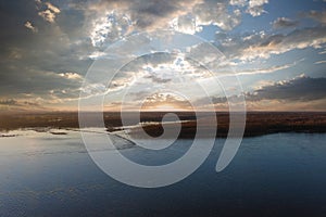 A stunning aerial shot of the vast blue waters of the Mississippi river with powerful clouds and a gorgeous sunset