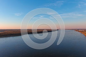 A stunning aerial shot of the vast blue waters of the Mississippi river with powerful clouds and a gorgeous sunset