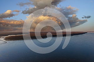 A stunning aerial shot of the vast blue waters of the Mississippi river with powerful clouds and a gorgeous sunset