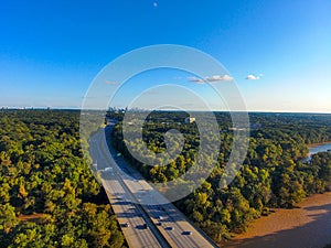 A stunning aerial shot of vast miles of lush green trees, the freeway, the Chattahoochee river and blue sky at sunset