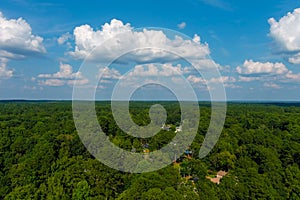 a stunning aerial shot of vast miles of lush green trees with homes nestled into the trees with a majestic sky