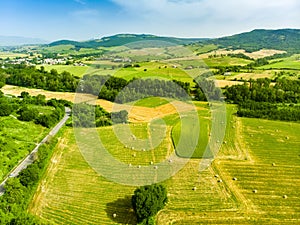 Stunning aerial view of green fields and farmlands. Summer rural landscape of rolling hills, curved roads and cypresses of Tuscany