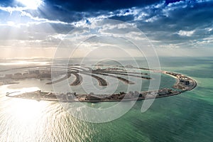 Stunning aerial view of Palm Jumeirah at sunset with sun rays on