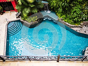 Stunning aerial view of a swimming pool with tropical trees all around