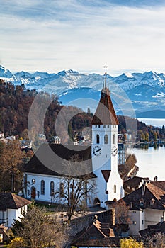 Stunning aerial view of Thun cityscape with Central Church, Aare river flowing to Lake Thun from Thun castle with Swiss Alps peaks