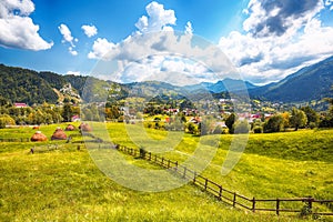 Stunning alpine landscape with green fields and Piatra Craiului mountains in Dambovicioara Commune