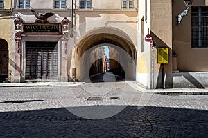 Stunning archway providing an inviting entrance between two tall buildings in Parma, Italy.