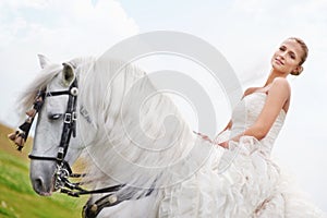 Stunning atop her steed - Wedding Day. A gorgeous bride posing for wedding photos atop her white horse.