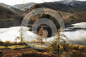 Stunning Autumn Fall landscape of Hawes Water with epic lighting and dramatic sunlight in Lake District