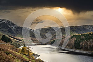 Stunning Autumn Fall landscape of Hawes Water with epic lighting and dramatic sunlight in Lake District