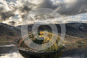 Stunning Autumn Fall landscape of Hawes Water with epic lighting and dramatic sunlight in Lake District