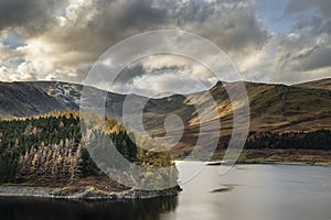 Stunning Autumn Fall landscape of Hawes Water with epic lighting and dramatic sunlight in Lake District