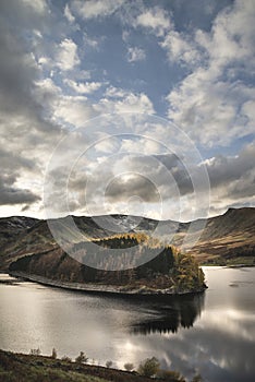 Stunning Autumn Fall landscape of Hawes Water with epic lighting and dramatic sunlight in Lake District