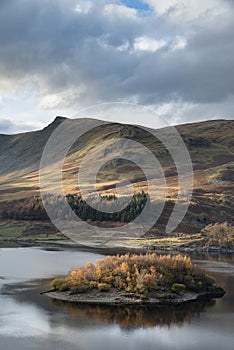 Stunning Autumn Fall landscape of Hawes Water with epic lighting and dramatic sunlight in Lake District