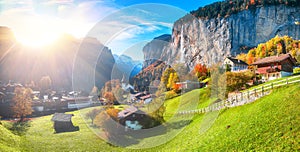 Stunning autumn landscape of  alpine village Lauterbrunnen with famous church and Staubbach waterfall