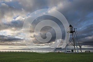 Stunning Autumn sunset landscape image of Sillloth lighthouse with Dumfries and Galloway mountains in distance