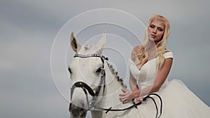 stunning beautiful blonde woman on horseback, portrait of pretty bride and white equine