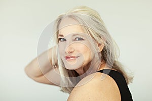 Stunning beautiful and self confident best aged woman with grey hair smiling into camera