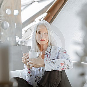 Stunning beautiful and self confident best aged woman with grey hair smiling into camera