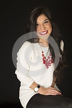 Stunning beauty female model sitting smiling black background