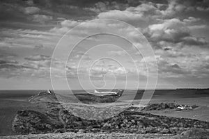 Stunning black and white landscape image of Belle Tout lighthouse on South Downs National Park during stormy sky