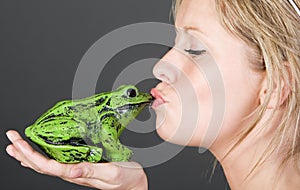 Stunning Blonde Girl Kissing a Frog photo