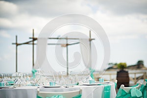 stunning blue trim decorates the back of these white folding chairs at this outdoor beach front reception