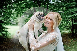 Stunning bride plays with a nice dog in the park