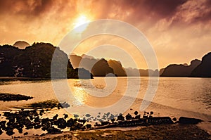 Stunning colorful sunset over the beautiful Karst stone mountain landscape of Ha Long Bay viewed from Cat Ba Island, Vietnam