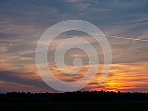 Stunning colorful sunset sky over a forest silhouette. Warm and cool color. Beautiful nature scene. Calm and relaxing mood and