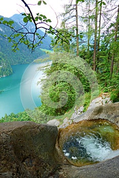 Stunning colorful waterfall falling to Konigsee known as Germany`s deepest and cleanest lake, located in Berchtesgadener National