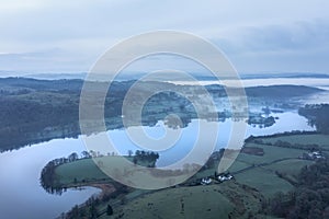 Stunning drone aerial landscape image of cloud inversion around Esthwaite Water in Lake District during Spring sunrise