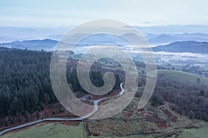 Stunning drone aerial landscape image of cloud inversion around Esthwaite Water in Lake District during Spring sunrise